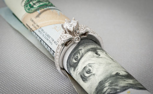 An engagement ring with a 100 dollar bill