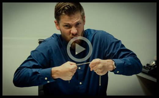 A man attempting to break a yellow gold chain