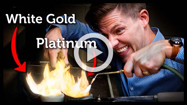 Angelo holds two torches to two crucibles with the labels white gold and platinum above them