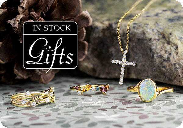 A group a jewelry gifts including three yellow gold gemstone rings and a yellow gold diamond cross necklace