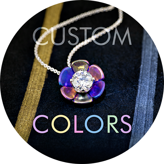 A titanium lotus flower pendant with petals of multiple colors with the text custom colors