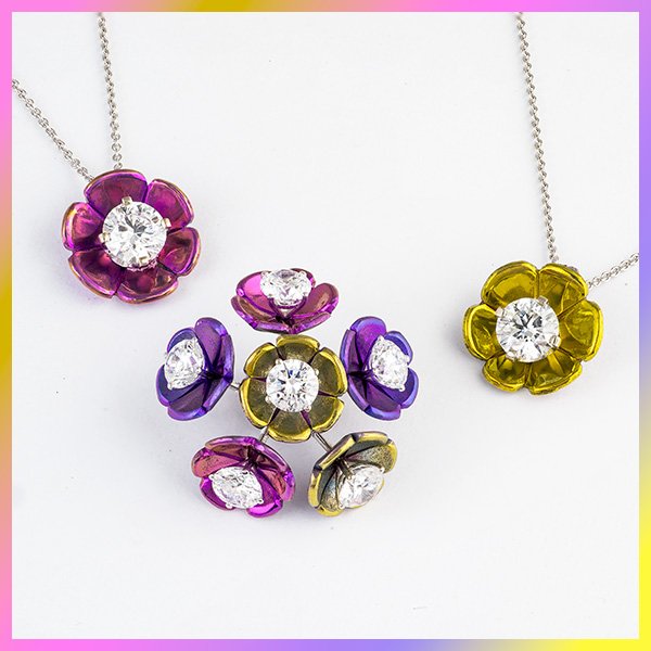 A bouquet of mult-colored titanium and lab diamond stud earrings with two floral pendants next to them