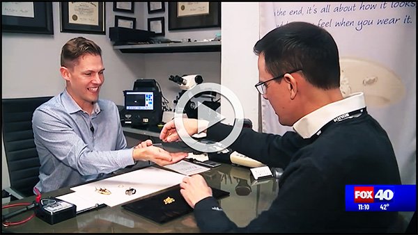 A FOX40 news reporter hands Angelo from Arden Jewelers some gold jewelry to evaluate