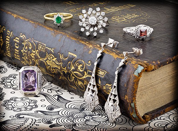 A group of vintage jewelry pieces resting on an old book