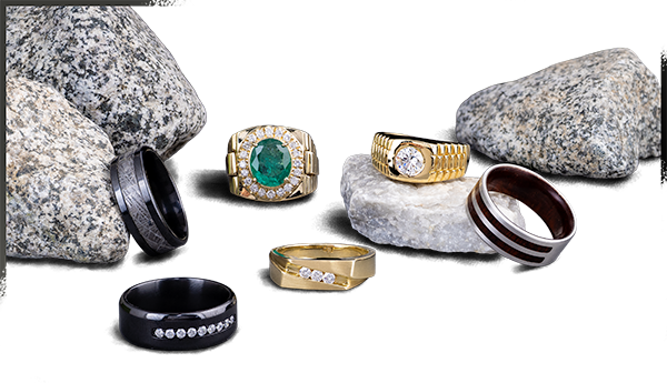 A group of new mens rings next to some rocks