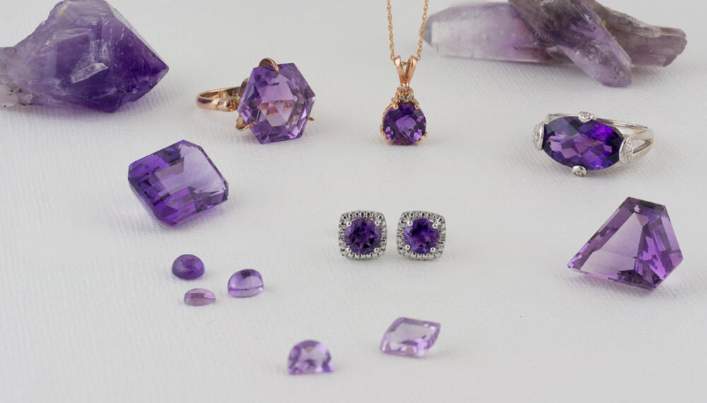 Group of loose amethyst gems cut and uncut with finished jewelry