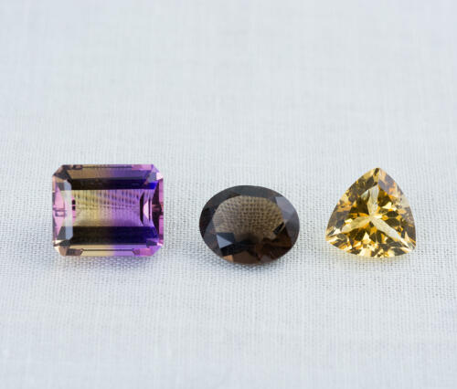 A group of three loose gemstones Ametrine Smoky Quartz and Citrine