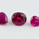 Three loose rubies in a row triangle oval and pear shaped