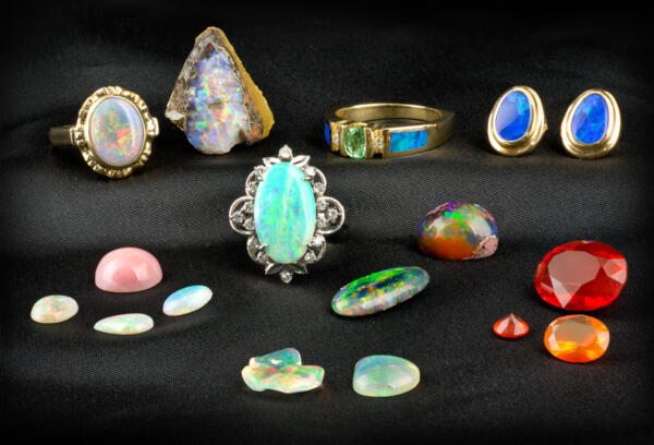 A group of several loose opal and rings with opals set in them