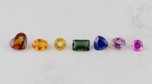 A row of loose sapphire gems in many different colors