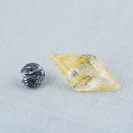 A rutilated quartz next to a tourmalinated quartz