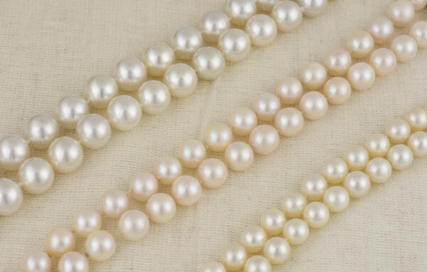 Three strands of white pearls laying next to each other