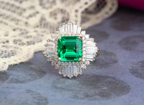 Custom green emerald engagement ring with ballerina halo