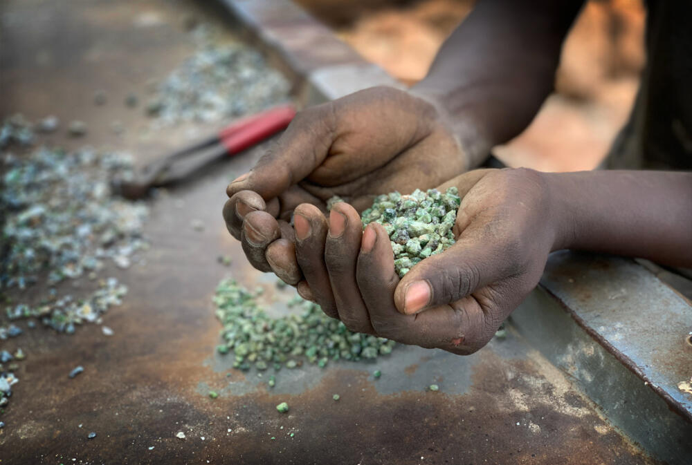East African gem miner holding rough gemstones