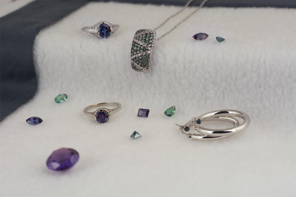 A group of alexandrite jewelrr and loose gems shown in fluorescent light