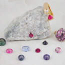 Group of loose spinel gemstones with finished jewelry