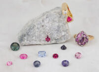 Group of loose spinel gemstones with finished jewelry