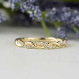 front angle yellow gold twisted diamond band on fancy background