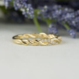 side angle yellow gold twisted diamond band on fancy background