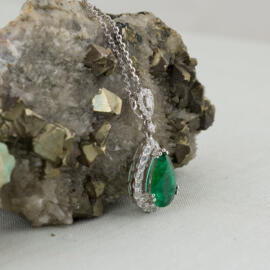 fancy background pear emerald diamond halo pendant left side view