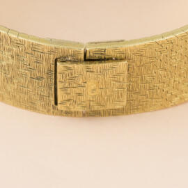 An closed fold over clasp on a yellow gold bracelet