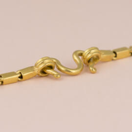 A high karat yellow gold M clasp design