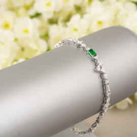 emerald diamond platinum tennis bracelet with flower background