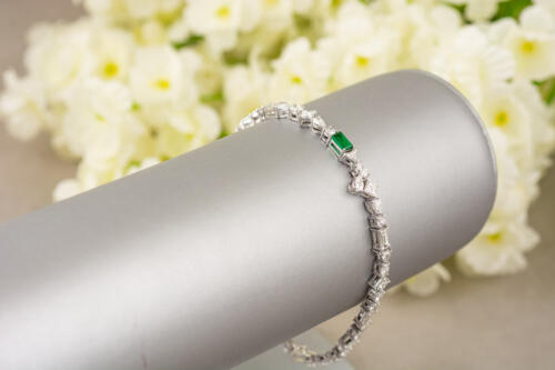 emerald diamond platinum tennis bracelet with flower background