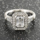 Custom emerald cut diamond halo engagement ring with engraved accents front