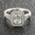 Custom emerald cut diamond halo engagement ring with engraved accents front