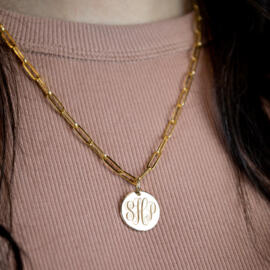Gold disc monogram necklace being worn