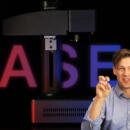 A picture of our new laser engraver with the text Laser and a person doing air quotes in front of it