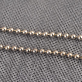 A close up of a white gold bead chain