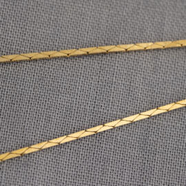 A close up of a yellow gold cobra chain