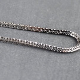 A close up of a white gold foxtail chain