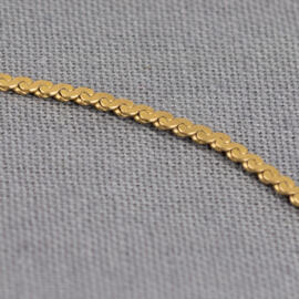 A close up of a yellow gold S-link chain