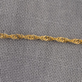 A close up of a yellow gold Singapore chain