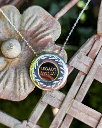 A necklace in silver and 18k yellow gold featuring the Legacy Classical Academy logo