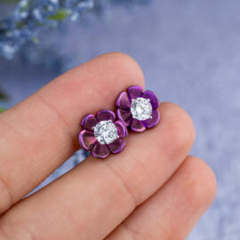 Magenta lotus blossom stud earrings with lab diamonds in 14k white gold in hand for perspective