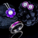 Group of brightly colored titanium jewelry pieces on a dark background