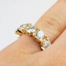 Custom yellow gold five stone diamond band on finger