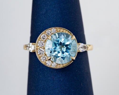 Custom blue topaz off center ring with diamond accents front view