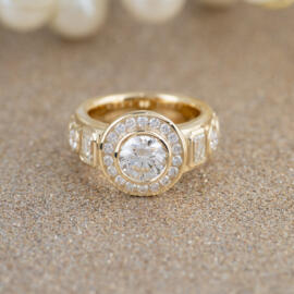 14 karat yellow gold custom diamond bezel ring with gold sparkle backdrop front view