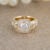 14 karat yellow gold custom diamond bezel ring with gold sparkle backdrop front view