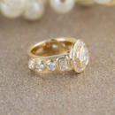14 karat yellow gold custom diamond bezel ring with gold sparkle backdrop side view