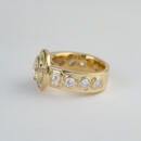 14 karat yellow gold custom diamond bezel ring with white backdrop side view