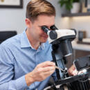 A gemologist at a microscope evaluating a piece of jewelry