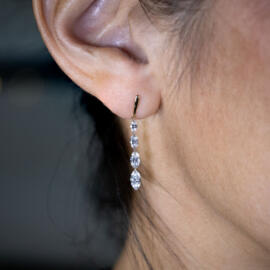 Lab grown drilled marquise diamond dangle earrings in 14k yellow gold on model right ear
